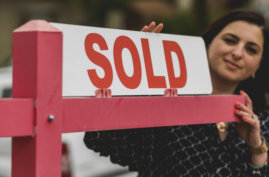 Realtor Putting Up a “Sold” Sign