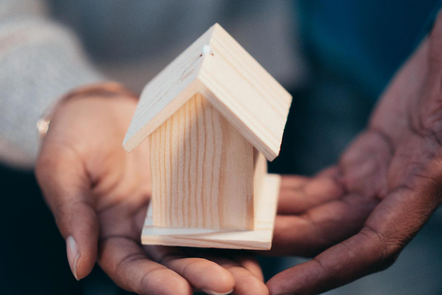 Real estate agent holding a mini wooden house